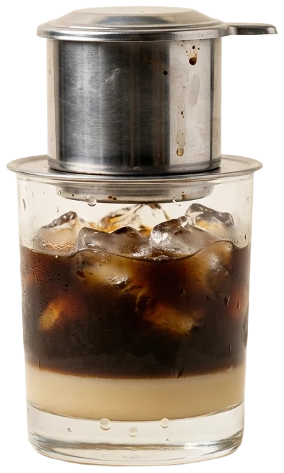 Vietnamese iced coffee dripping from a steel phin filter into a glass of condensed milk and ice